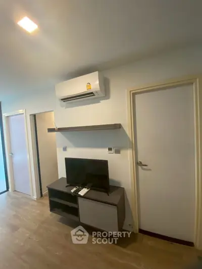 Modern living room with air conditioning and sleek TV setup, perfect for comfortable living.