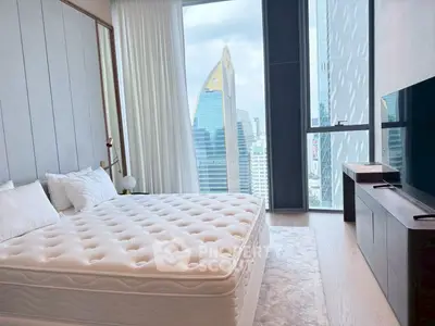 Luxurious bedroom with stunning city view and modern decor in high-rise apartment.