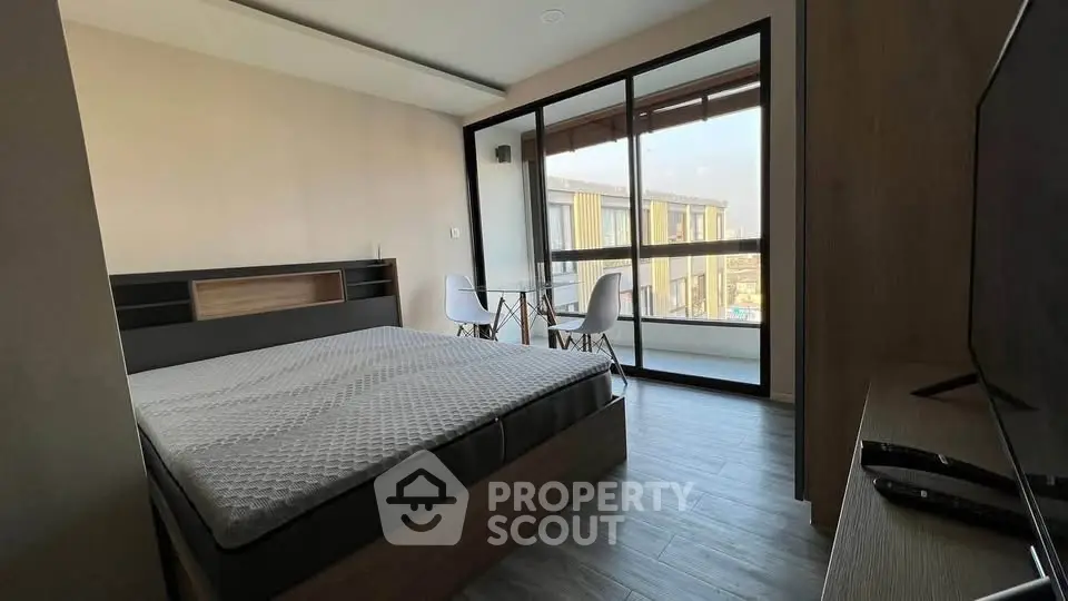 Modern bedroom with balcony view and stylish furniture in urban apartment