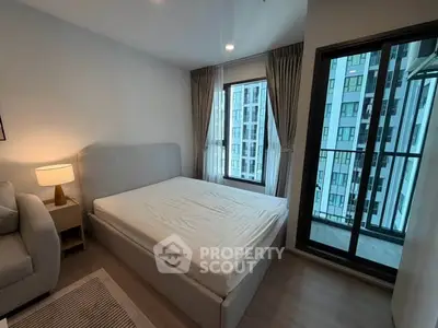 Modern bedroom with large windows and cozy furnishings in a high-rise apartment.