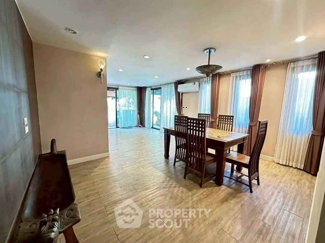 Spacious dining area with elegant wooden furniture and large windows for natural light.