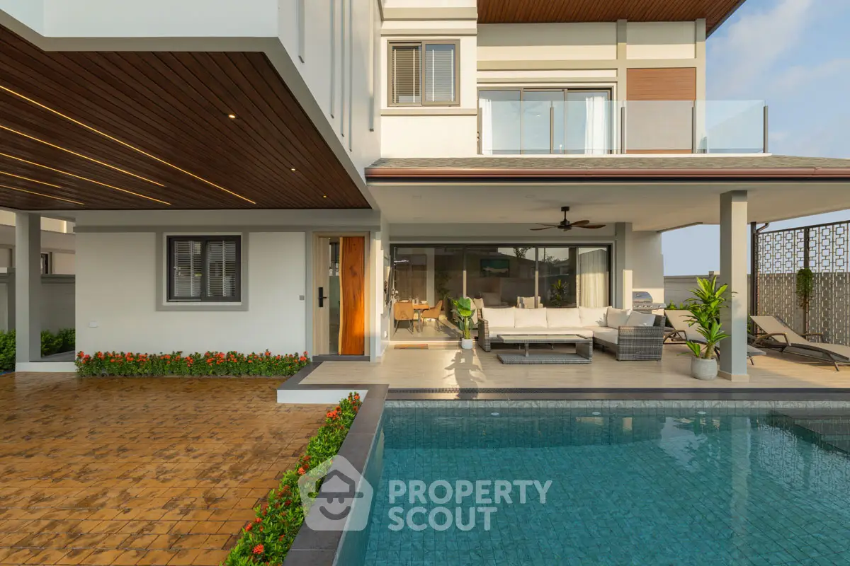 Luxurious modern home with poolside patio and spacious balcony, perfect for relaxation and entertainment.