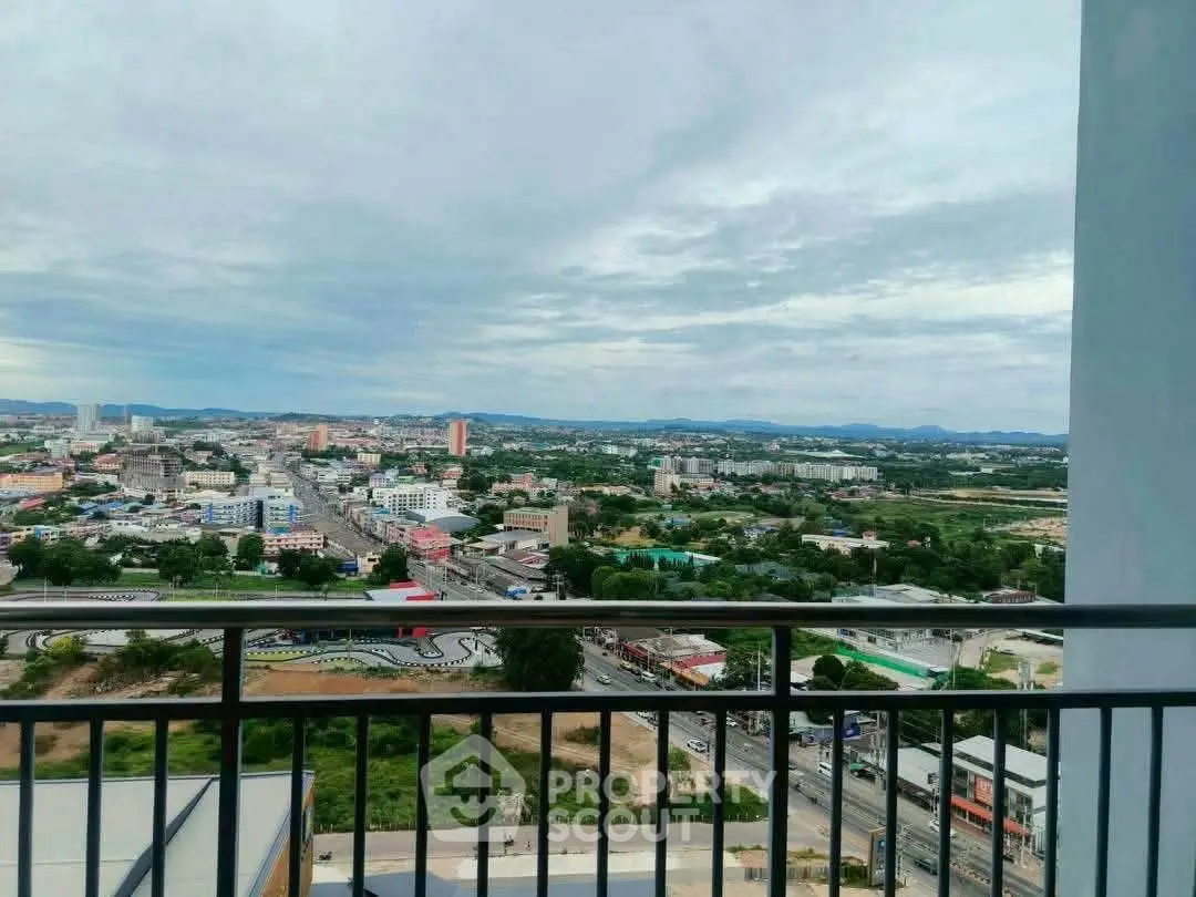 Stunning cityscape view from a high-rise balcony, showcasing urban landscape and distant mountains.