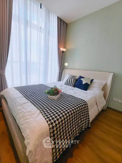 Cozy bedroom with stylish decor and large window for natural light