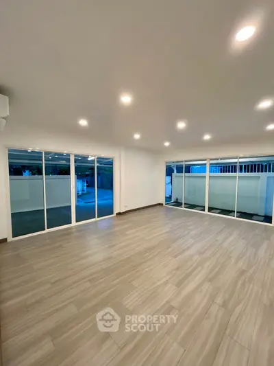 Spacious modern living room with large windows and sleek flooring