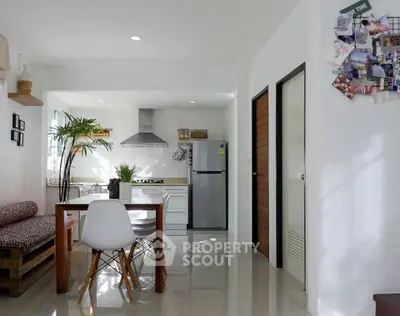 Modern kitchen with open layout and dining area, featuring sleek appliances and contemporary decor.