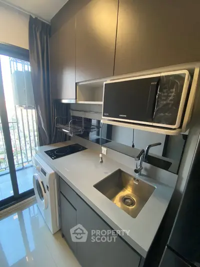 Modern compact kitchen with sleek cabinetry and city view balcony