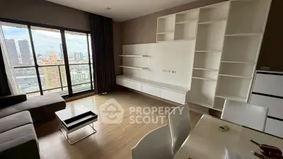 Modern living room with city view, featuring sleek furniture and large windows for natural light.