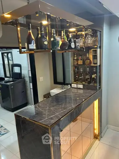 Luxurious home bar with marble countertop and elegant bottle display, perfect for entertaining guests.