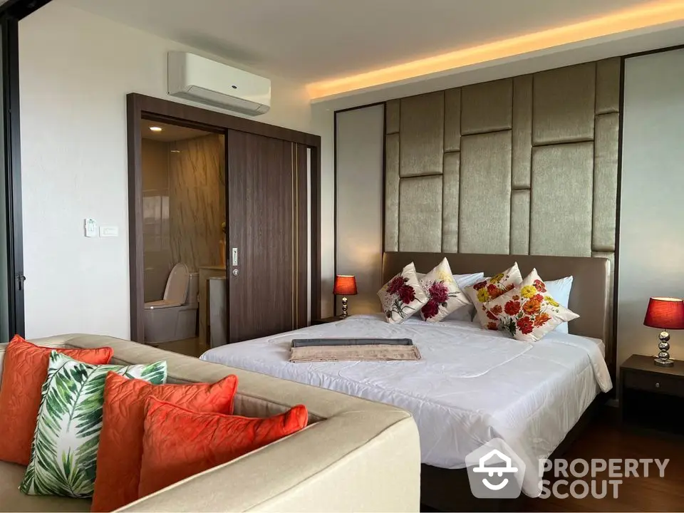 Luxurious bedroom with modern decor and ensuite bathroom in a stylish apartment.