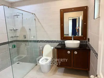Modern bathroom with glass shower and stylish vanity in elegant home.