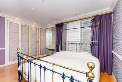 Luxurious bedroom with elegant metal bed frame and spacious built-in wardrobes