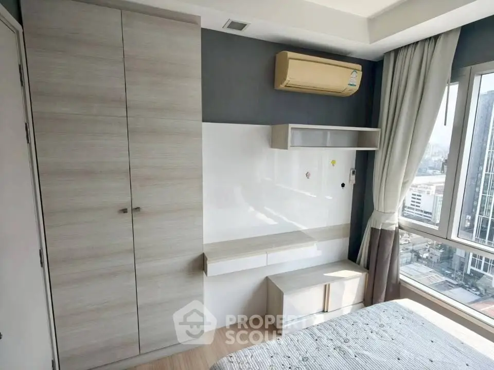 Modern bedroom with built-in wardrobe and city view window