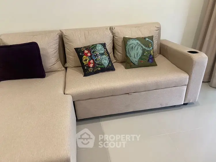 Modern beige sofa with colorful cushions in a stylish living room setting.