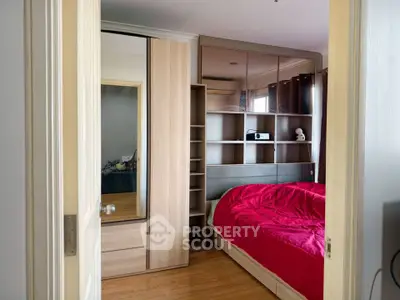 Cozy bedroom with red bedding and modern wooden furniture