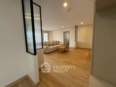 Spacious modern living room with wooden flooring and cozy seating area.