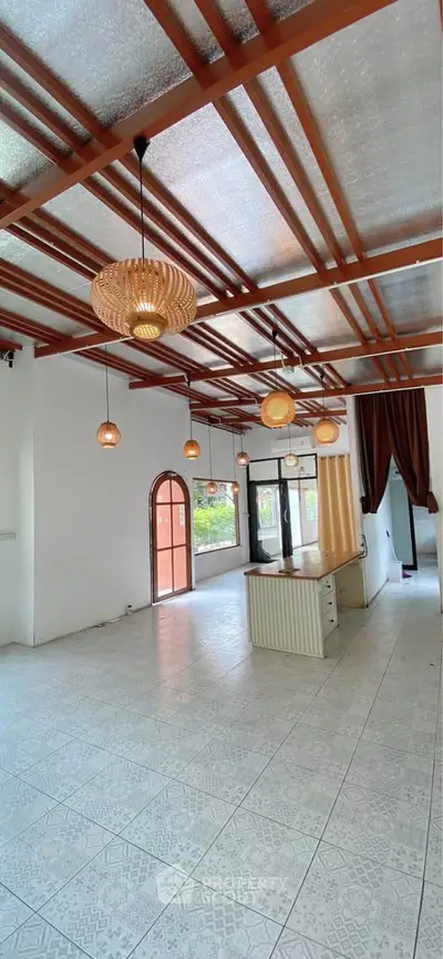 Spacious living room with modern lighting and large windows for natural light.
