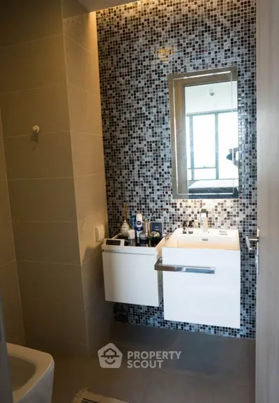 Modern bathroom with mosaic tile wall and sleek vanity