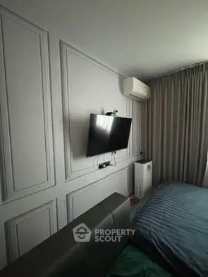 Modern bedroom with wall-mounted TV and air conditioning unit