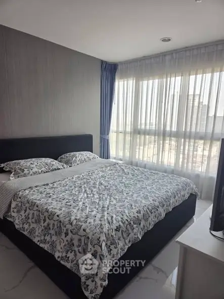 Modern bedroom with large window and stylish decor in urban apartment