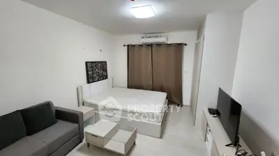Modern studio apartment with cozy living area and bed, featuring neutral decor and natural light.