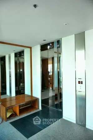 Modern building entrance with sleek elevator and stylish decor