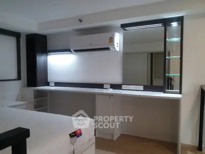 Modern studio apartment with sleek built-in kitchenette, ample storage, and a comfortable living space, perfect for urban living.