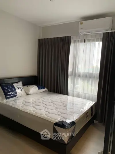 Modern bedroom with large window and air conditioning in a stylish apartment.