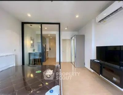 Modern bedroom with sleek design, featuring a large bed, TV, and air conditioning in a bright, spacious apartment.