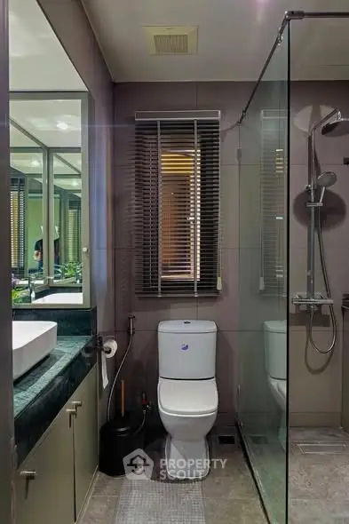 Modern bathroom with glass shower and sleek fixtures in a contemporary home.