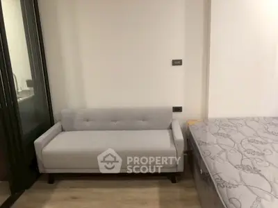 Modern studio apartment with cozy gray sofa and stylish bed, perfect for urban living.