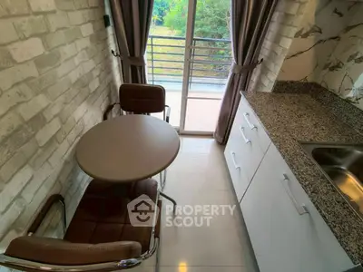 Cozy kitchen with balcony view, modern design, and granite countertops.