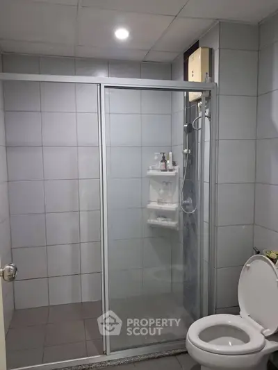 Modern bathroom with glass shower enclosure and tiled walls