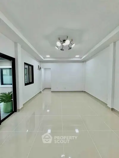 Spacious modern living room with elegant lighting and glossy tiled flooring.