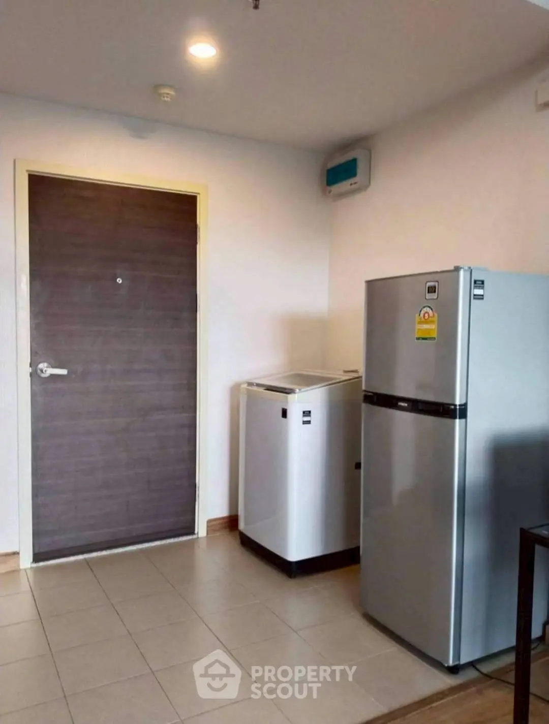 Modern kitchen with fridge and washing machine in compact space
