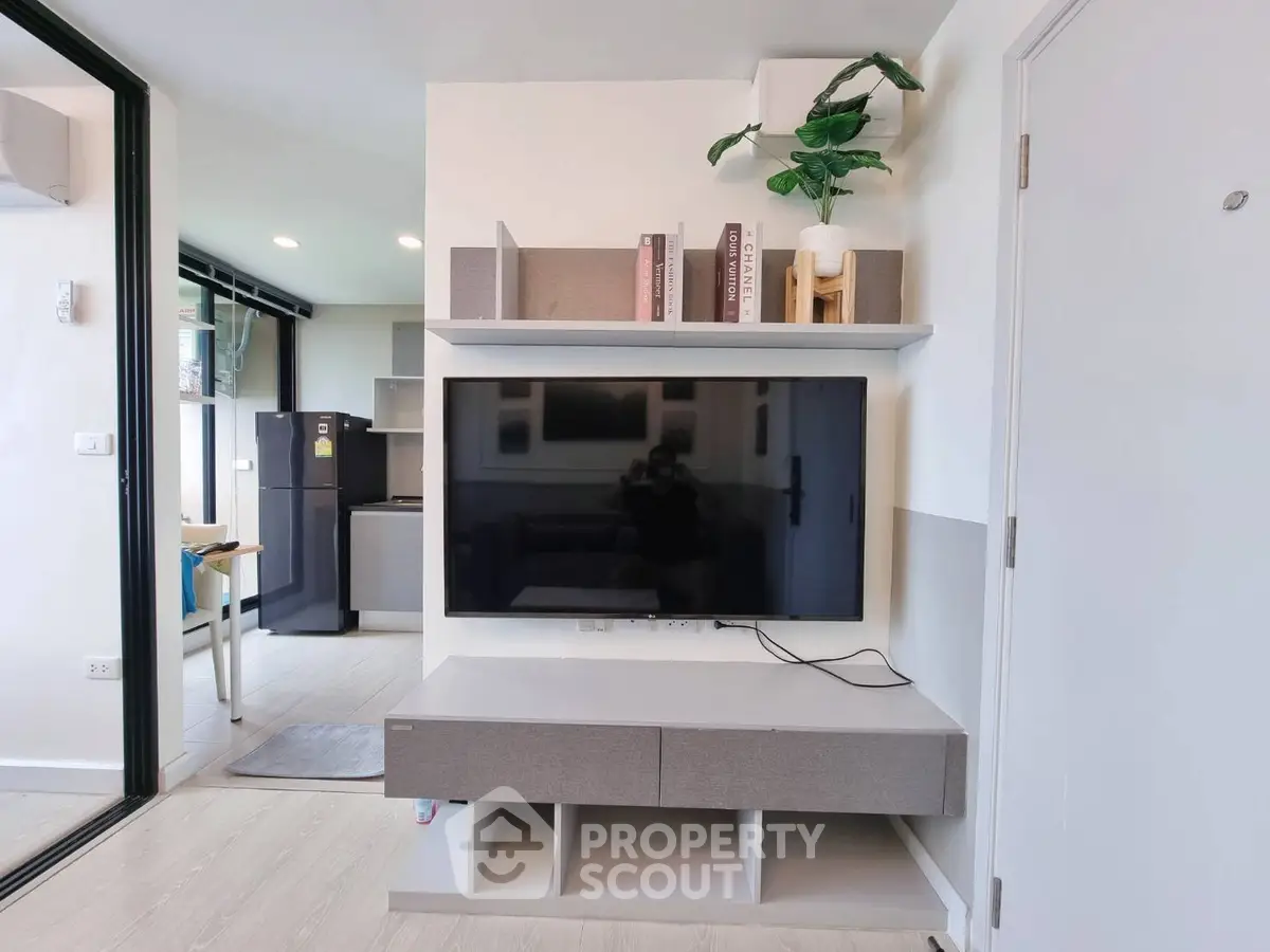 Modern living room with sleek TV unit and open kitchen view