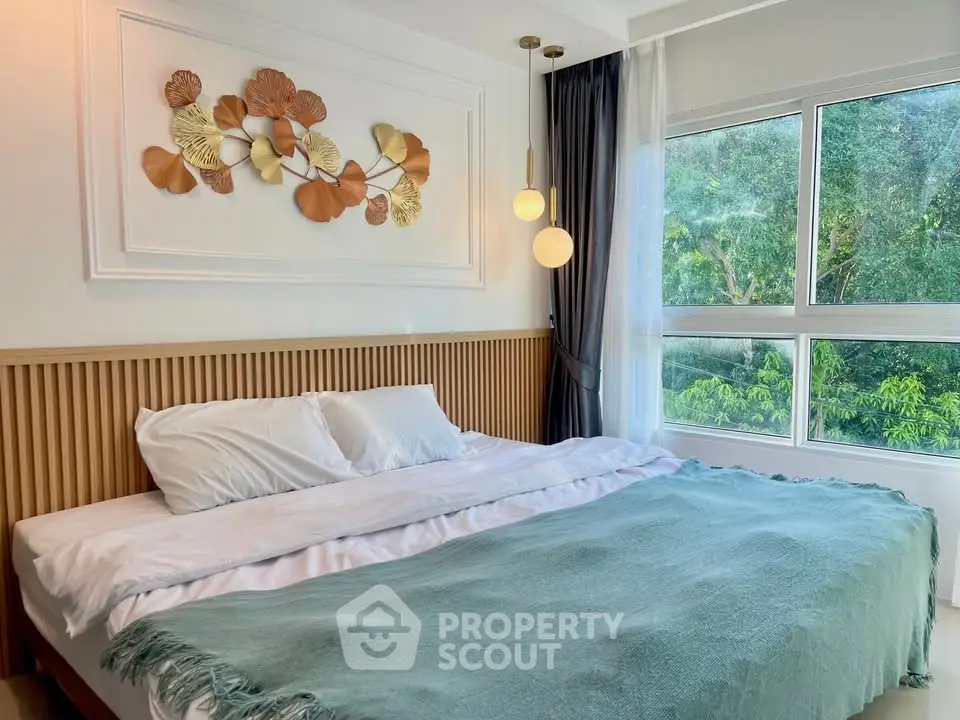 Luxurious bedroom with large window and elegant decor overlooking lush greenery.
