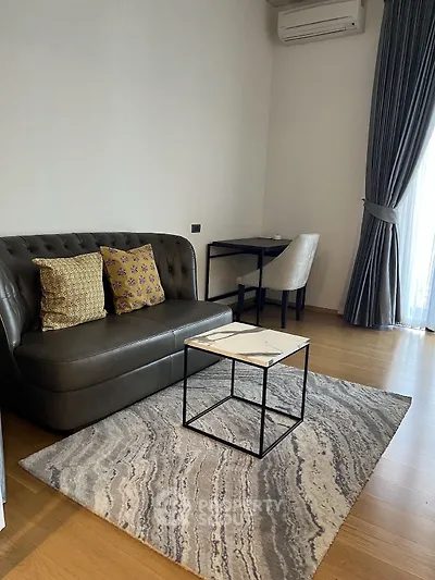Modern living room with stylish sofa, elegant rug, and natural light from large window.