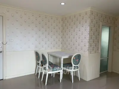 Charming dining nook with vintage floral chairs and elegant wallpaper