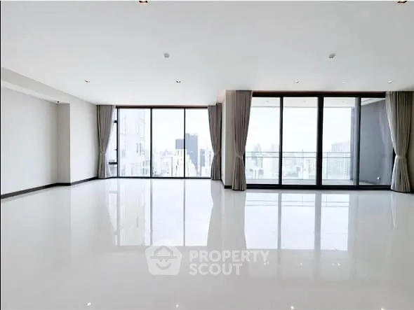 Spacious modern living room with large windows and city view, perfect for urban living.