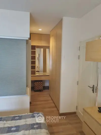 Modern bedroom with built-in wardrobe and wooden flooring, perfect for stylish living.