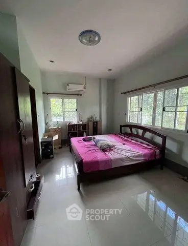 Spacious bedroom with large windows and modern furnishings