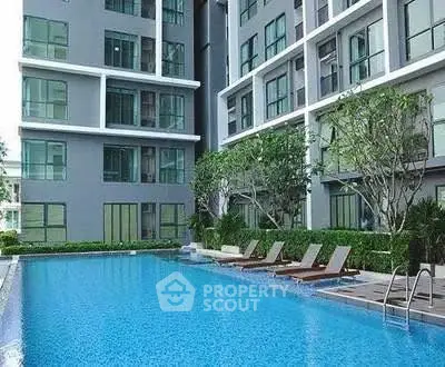 Modern apartment building with a luxurious outdoor pool and lush greenery.