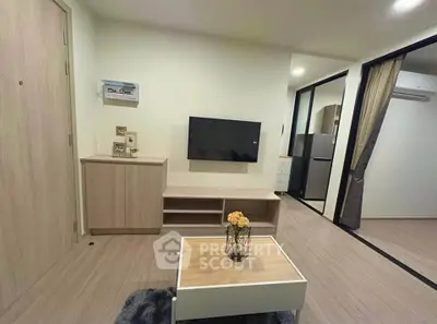 Modern living room with sleek furniture and wall-mounted TV in a cozy apartment.