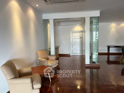 Spacious living room with elegant wooden flooring and cozy seating area.