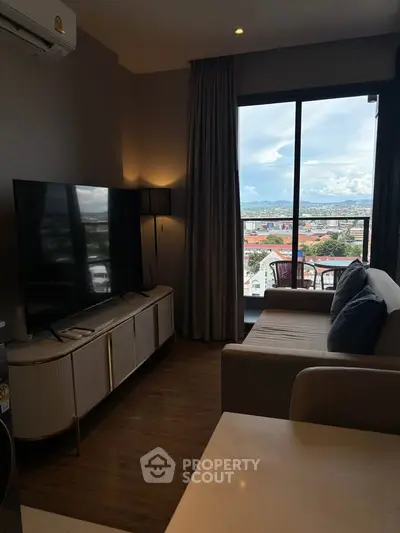 Modern living room with large TV and stunning city view from balcony.