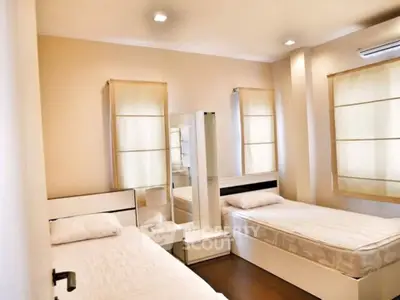 Bright twin bedroom with modern furnishings and natural light