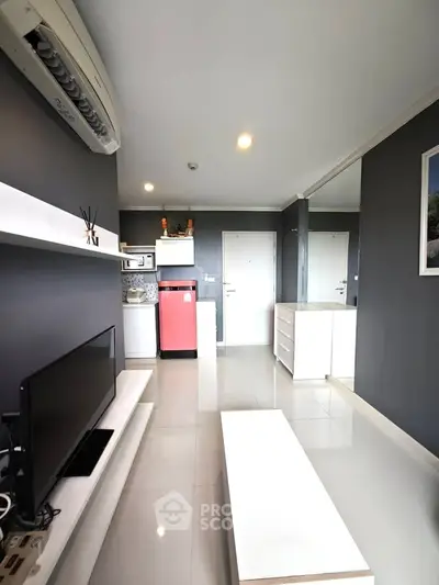 Modern living room with sleek design, featuring a red fridge and minimalist decor.