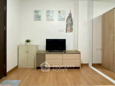 Modern living room with wooden flooring, stylish TV stand, and decorative wall art.
