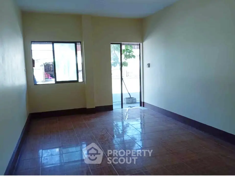 Spacious empty room with large windows and tiled flooring, perfect for customization.